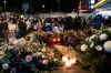 People lay flowers and light candles for the victims of the fire at the 