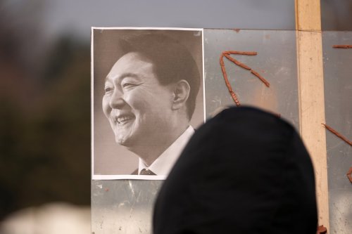 A picture of former South Korean President Yoon Suk Yeol is placed on a board as supporters gather outside Seoul Central District Court, in Seoul, South Korea, Friday, Jan. 16, 2026. (AP Photo/Lee Jin-man)