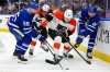 Philadelphia Flyers Emil Andrae (36) tries to move the puck between Toronto Maple Leafs Nicolas Roy (55) and teammate Dakota Joshua (81) during second period NHL hockey action in Toronto, Monday, March 2, 2026. THE CANADIAN PRESS/Frank Gunn
