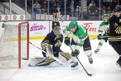 Goalie Jayden Kraus (33) of the Brandon Wheat Kings and Alisher Sarkenov (24) of the Prince Albert Raiders eye the puck during WHL action at Assiniboine Credit Union Place on Friday evening. (Tim Smith/The Brandon Sun)