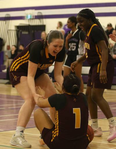 Crocus Plainsmen senior Kate Hiebert helps Genesis Lopez Mejia up after Lopez Mejia drew a charge during Game 2 of the varsity girls basketball city final against the Vincent Massey Vikings on Thursday. (Thomas Friesen/The Brandon Sun)