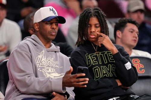 Basketball player Chris Paul, left, sits with his son Chris Paul Jr. during the second half of an NCAA college basketball game between Southern California and Northwestern, Wednesday, Jan. 21, 2026, in Los Angeles. (AP Photo/Mark J. Terrill)