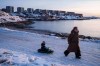 A woman pulls her child on a sled in Nuuk, Greenland, on Sunday, Jan. 25, 2026. (AP Photo/Evgeniy Maloletka)