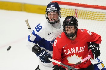 Finland's Ronja Savolainen, left, and Blayre Turnbull of Canada eye the puck during the semi final match between Canada and Finland at the Women's Ice Hockey Championships in Ceske Budejovice, Czech Republic, Saturday, April 19, 2025. (AP Photo/Petr David Josek)