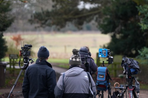 Journsalists wait at the entrance gate of the Sandringham Royal Estate in Sandringham, England, Friday, Feb. 20, 2026 after Andrew Mountbatten-Windsor was arrested and held for hours by British police on suspicion of misconduct in public office related to his links to Jeffrey Epstein.(AP Photo/Alastair Grant)