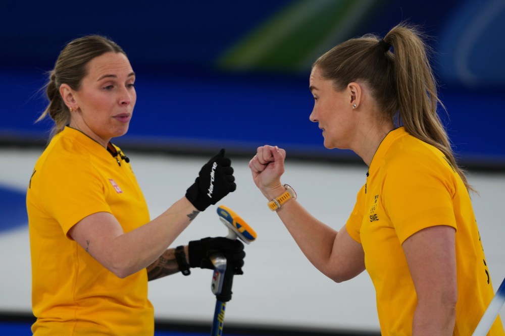 2026年2月22日日曜日、イタリアのコルティナ・ダンペッツォで開催された2026年冬季オリンピックのスイス対スウェーデンの女子カーリング金メダル決定戦で反応するスウェーデンのソフィア・シャルバッハ選手（左）とスウェーデンのサラ・マクマナス選手（左）。（AP写真/ミスパー・アパーヴ）