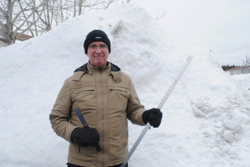 Sixty-two-year-old Lloyd Leaman stands in front of a towering snow bank in Paradise, N.L., on Wednesday Feb. 25, 2026. THE CANADIAN PRESS/Sarah Smellie