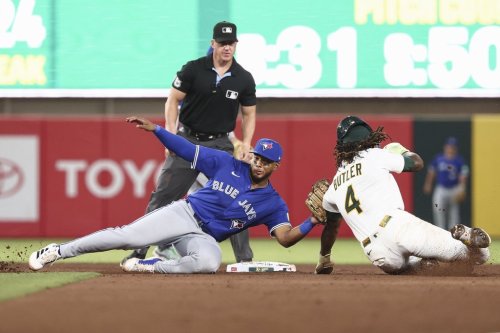 Athletics' Lawrence Butler (4) is tagged out stealing second base by Toronto Blue Jays second baseman Leo Jiménez, left, during the fifth inning of a baseball game Saturday, July 12, 2025, in West Sacramento, Calif. (AP Photo/Sara Nevis)