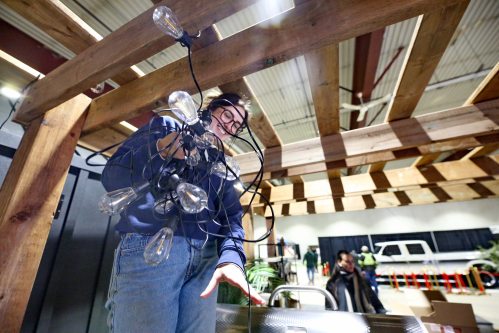 Livingstone Outdoor merchandise co-ordinator Maddy Jackson handles a set of large outdoor lights that she is placing on a wooden pergola on Thursday afternoon at the Keystone Centre. The Brandon-based business joined dozens of other companies as participants in the Brandon Home and Leisure Show, which starts today. The three-day event is a must-see for anyone looking for home renovation and residential improvement ideas, and includes free family entertainment, a golf simulator and a speaker series.
