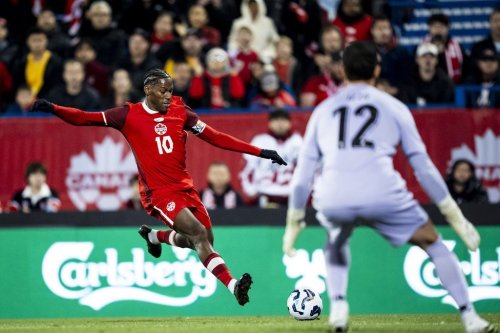 Canada's Jonathan David (10) shoots on Australian goalkeeper Paul Izzo (12) during an international men's soccer friendly in Montreal on Friday, Oct. 10, 2025. THE CANADIAN PRESS/Christopher Katsarov