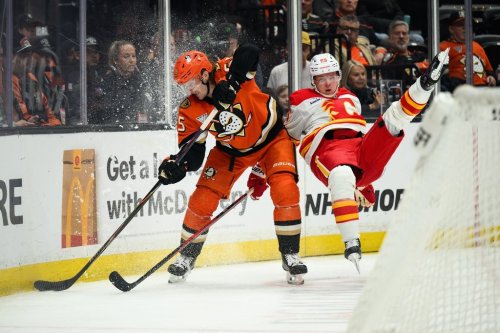 Anaheim Ducks defenceman Jacob Trouba, left, controls the puck while under pressure from Calgary Flames left wing Victor Olofsson (95) during the second period of an NHL hockey game Saturday, April 4, 2026, in Anaheim, Calif. (AP Photo/William Liang)