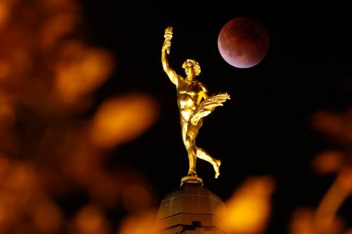 A Lunar eclipse is shown behind the Golden Boy at the Manitoba Legislature in September 2015. A lunar eclipse will happen early Tuesday morning, and Abby Wronowski recommends getting up to witness the spectacle. (John Woods/Winnipeg Free Press files)