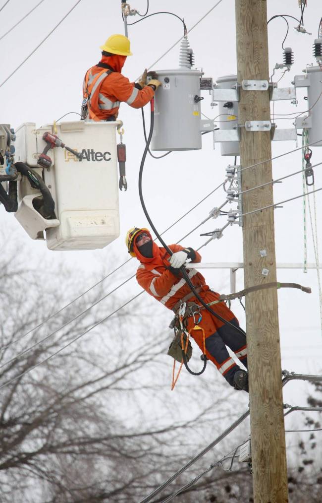 A pair of Manitoba Hydro employees work on an electrical transformer high up on a hydro pole on Pacific Avenue on a cold and windy Wednesday afternoon. (Matt Goerzen/The Brandon Sun)
