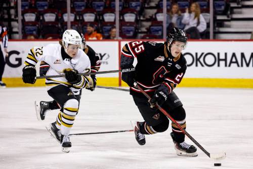 Brandon Wheat Kings forward Brett Wilson (22) pursues Calgary Hitmen forward Shaun Hildebrandt (25) up the ice during Game 2 of their Western Hockey League quarterfinal series at Scotiabank Saddledome on Sunday. Calgary won 6-5 in overtime. (Jenn Pierce/Calgary Hitmen)