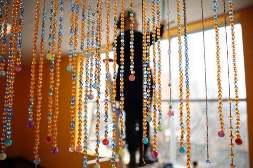 Lucie Lederhendler, artistic director and curator for the Art Gallery of Southwestern Manitoba, hangs the &ldquo;Tears of Truth&rdquo; bead curtain exhibit on Wednesday in advance of tonight&rsquo;s opening in the community gallery along with Justina McKay&rsquo;s exhibit &ldquo;Reconciliation, Resilience, and Red.&rdquo; The bead curtain was created by Brandon-area students and community members as an intentional act of remembrance of those impacted by the residential school system. The opening reception for both exhibits takes place tonight at 5 p.m. (Photos by Tim Smith/The Brandon Sun)