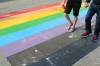 People walk on a Pride flag crosswalk in Calgary in August 2019. An Alberta town has passed a bylaw that effectively bans such crosswalks from public land. (The Canadian Press)
