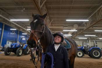 Zoe Gerein stands alongside her horse, Lily, as they prepare for a jumper competition at the Royal Manitoba Winter Fair at the Keystone Centre in Brandon on Tuesday. Gerein said rising costs have 