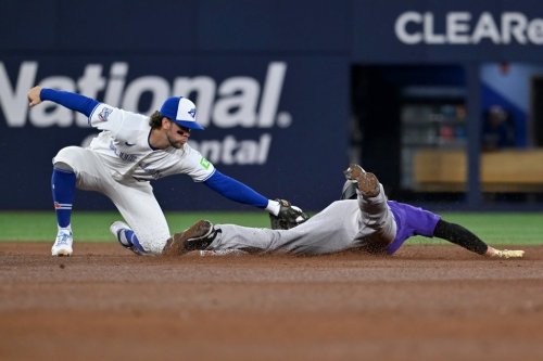 Toronto Blue Jays infielder Ernie Clement (22) tags out Colorado Rockies outfielder Hunter Goodman (15) on an attempted stolen base to end the fifth inning of interleague baseball action in Toronto on Monday, March 30, 2026. THE CANADIAN PRESS/Jon Blacker