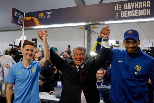 Joan Laporta, center, reacts as he poses with players Gavi, left, and Ronald Araujo after the voting for the election to be president of FC Barcelona in Barcelona, Spain, Sunday, March 15, 2026. (AP Photo/Joan Monfort)