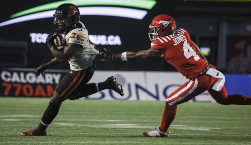 B.C. Lions' Micah Awe, left, runs an interception as Calgary Stampeders' Tevin Jones grabs for him during first half CFL football action in Calgary, Friday, Sept. 19, 2025. THE CANADIAN PRESS/Jeff McIntosh