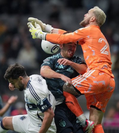 Seattle Sounders goalkeeper Stefan Frei, right, collides with teammate Jackson Ragen, centre, as he vies for the ball against Vancouver Whitecaps' Brian White, left, during the second half of a CONCACAF Champions Cup soccer match, in Vancouver, on Thursday, March 12, 2026. THE CANADIAN PRESS/Darryl Dyck