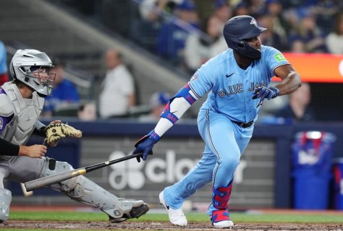 Toronto Blue Jays' Jesus Sanchez (right) hits an RBI single as Colorado Rockies catcher Hunter Goodman (15) looks on during fifth inning MLB baseball action in Toronto on Tuesday, March 31, 2026. THE CANADIAN PRESS/Nathan Denette