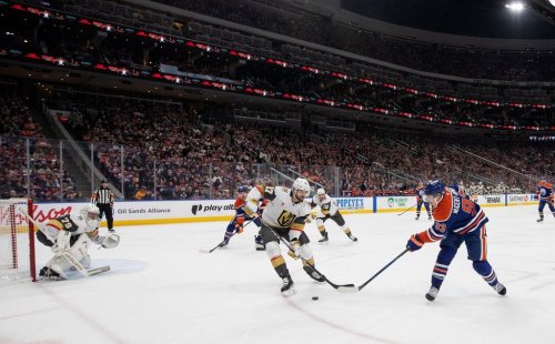 Vegas Golden Knights' Shea Theodore (27) and Edmonton Oilers' Ryan Nugent-Hopkins (93) battle for the puck goalie Carter Hart (79) keeps an eye on it during second period NHL action, in Edmonton on Saturday April 4, 2026. THE CANADIAN PRESS/Jason Franson