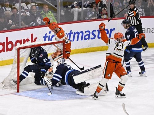 Anaheim Ducks' Tim Washe (front right) celebrates his goal on Winnipeg Jets goaltender Connor Hellebuyck (37) as Haydn Fleury (24) falls into the net during the second period of their NHL hockey game in Winnipeg, Tuesday March 10, 2026. THE CANADIAN PRESS/Fred Greenslade