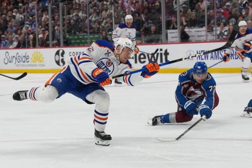 Edmonton Oilers right wing Vasily Podkolzin, front, shoots the puck as Colorado Avalanche defenceman Sam Malinski covers in the second period of an NHL hockey game Tuesday, March 10, 2026, in Denver. (AP Photo/David Zalubowski)