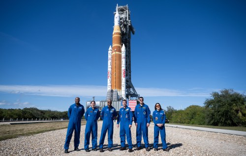 Artemis II backup crewmembers NASA astronaut Andre Douglas, left to right, and Canadian Space Agency astronaut Jenni Gibbons pose for a group photo with prime crewmembers NASA astronauts Victor Glover, Reid Wiseman, CSA astronaut Jeremy Hansen, and NASA astronaut Christina Koch, in front of NASA's Space Launch System (SLS) rocket and Orion spacecraft, secured to the mobile launcher, as it makes the 4.2 mile journey from the Vehicle Assembly Building to Launch Pad 39B at NASA's Kennedy Space Center in Cape Canaveral, Fla., in a Saturday, Jan. 17, 2026, handout photo. THE CANADIAN PRESS/Handout - NASA, Joel Kowsky (Mandatory Credit)