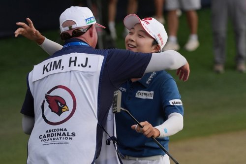 Hyo Joo Kim, right, of South Korea, celebrates with caddie Travis Wilson after winning the LPGA Ford Championship golf tournament, Sunday, March 29, 2026, in Chandler, Ariz. (AP Photo/Ross D. Franklin)