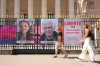 FILE - People walk past the portraits of French nationals Cecile Kohler and Jacques Paris in front of the French National Assembly in Paris on July 3, 2025. (AP Photo/Aurelien Morissard, File)