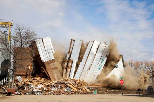 The grain elevator in Austin, built in 1951, comes crashing down on Wednesday during demolition by members of Pine Creek Hutterite Colony. (Photos by Tim Smith/The Brandon Sun)