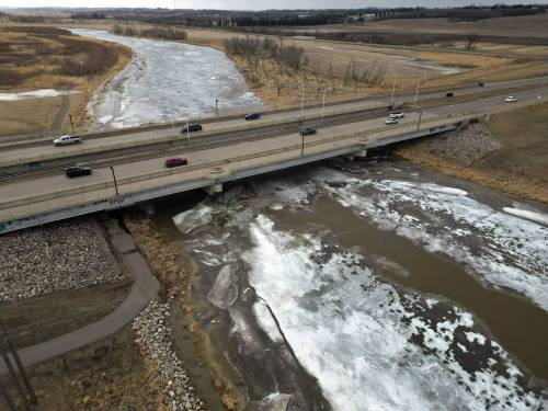 Traffic on the 18th Street bridge passes over the swollen and partially frozen Assiniboine River on Friday evening. The province has issued a high-water advisory for the Assiniboine River between the Shellmouth Dam near Russell and Portage la Prairie as snowmelt raises the river level. (Tim Smith/The Brandon Sun)