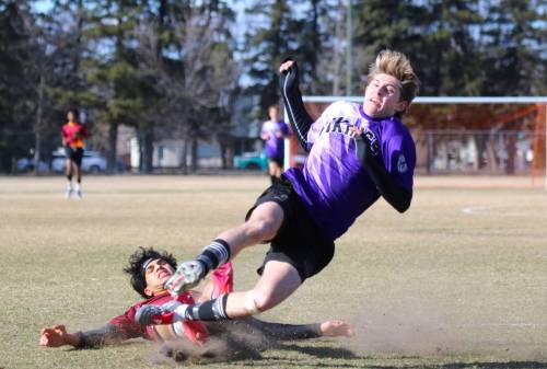 Crocus Plainsmen Mohamad Alabeid completes a successful slide tackle, taking Vincent Massey forward Jaxson Brick down in the process during their Brandon High School Soccer League season opener at Massey on Monday. (Thomas Friesen/The Brandon Sun)