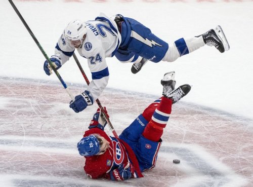 Tampa Bay Lightning's Max Crozier (24) checks Montreal Canadiens' Juraj Slafkovsky (20) during second-period NHL playoff hockey action in Montreal on Sunday, April 26, 2026. THE CANADIAN PRESS/Christinne Muschi