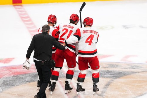 Carolina Hurricanes defenceman Alexander Nikishin (21) is helped off the ice by teammates Seth Jarvis (24) and Shayne Gostisbehere (4) after being checked by Ottawa Senators defenceman Tyler Kleven (43) during second period of first round Game 4 NHL playoff hockey action in Ottawa on Saturday, April 25, 2026. THE CANADIAN PRESS/Sean Kilpatrick