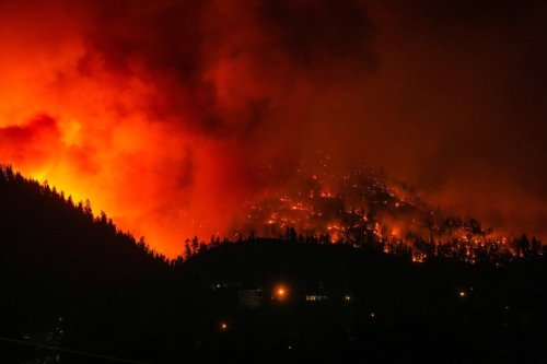 The McDougall Creek wildfire burns on the mountainside above houses in West Kelowna, B.C., on Friday, August 18, 2023. THE CANADIAN PRESS/Darryl Dyck