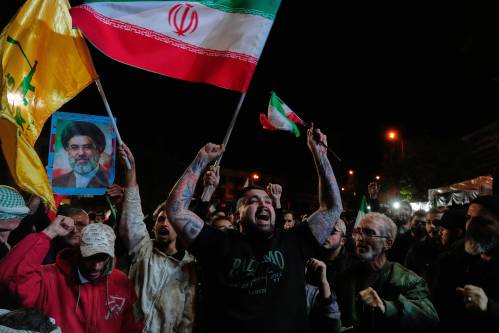 Pro-government demonstrators chant slogans as they hold Iranian flags and a poster of the Supreme Leader Ayatollah Mojtaba Khamenei in a gathering after announcement of a two-week ceasefire in the war with the United States and Israel, at the Enqelab-e-Eslami, or Islamic Revolution, Square, in Tehran, Iran, Wednesday, April 8, 2026. (AP Photo/Vahid Salemi)