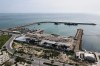 Backdropped by ships in the Strait of Hormuz, damage caused according to local witnesses by recent airstrikes is seen on a fishing pier in the port of Qeshm Island, Iran on Monday, April 13, 2026. (AP Photo/Asghar Besharati)