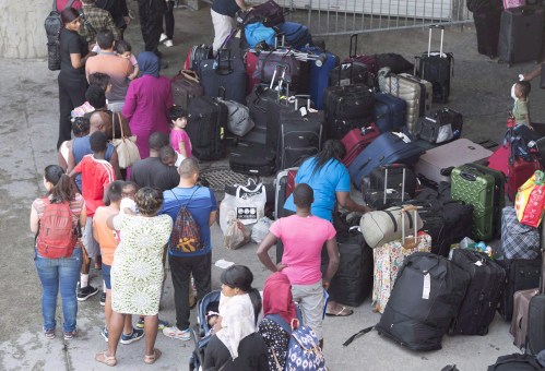 Asylum seekers line up to enter Olympic Stadium Friday, August 4, 2017 near Montreal, Quebec. THE CANADIAN PRESS/Paul Chiasson