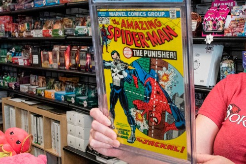 FILE - A game store manager holds the graded AM129 Spiderman 