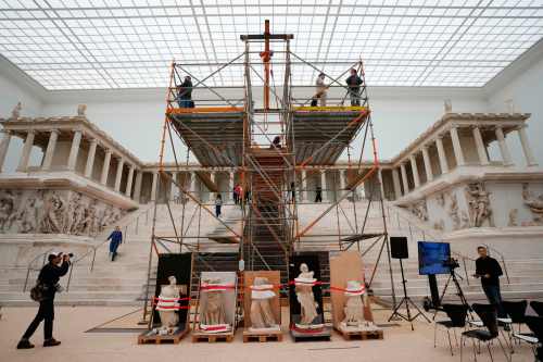 FILE - Journalists look at the Great Altar of Pergamon, during a press tour of the renovation construction site of the Pergamon Museum in Berlin, Germany, Dec. 4, 2025. (AP Photo/Markus Schreiber, File)