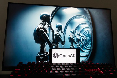 The OpenAI logo is seen displayed on a cellphone with an image on a computer screen generated by ChatGPT's Dall-E text-to-image model, Friday, Dec. 8, 2023, in Boston. (AP Photo/Michael Dwyer)