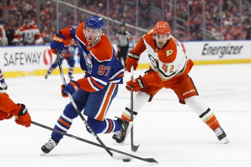 Anaheim Ducks' Tim Washe (42) pursues Edmonton Oilers' Connor McDavid (97) during second period NHL playoff action in Edmonton on Monday, April 20, 2026. THE CANADIAN PRESS/Codie McLachlan