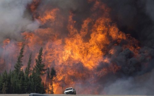 A giant fireball is seen as a wild fire rips through the forest 16 km south of Fort McMurray, Alta., on Highway 63 on May 7, 2016. THE CANADIAN PRESS/Jonathan Hayward