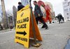 Pedestrians walk past an advance polling station sign and Calgary Flames logo outside Calgary City Hall in Calgary, Alta., Friday, April 12, 2019. THE CANADIAN PRESS/Jeff McIntosh