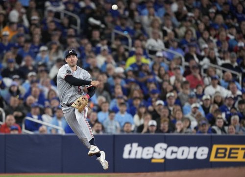 Minnesota Twins third baseman Ryan Kreidler (5) makes a leaping throw to out Toronto Blue Jays designated hitter George Springer at first base during third inning American League MLB baseball action in Toronto on Saturday, April 11, 2026. THE CANADIAN PRESS/Nathan Denette