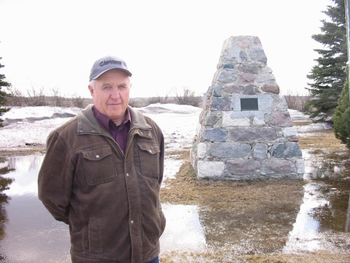Charlie Baldock in a file photo from 2011 stands near the cairn where the village of Wakopa began, before the townsite was moved north to be next to the rail line in the early 1900s. (Bill Redekop/Winnipeg Free Press files)