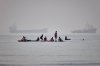 People gather on paddleboards in shallow water as cargo and service vessels are anchored in the Strait of Hormuz off Bandar Abbas, Iran, Monday, June 1, 2026. (Amirhosein Khorgooi/ISNA via AP)